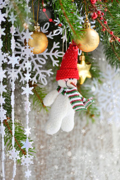 Snowman with Christmas ornaments on the branches of spruce