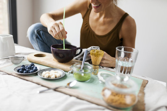 Woman preparing matcha latte at home