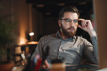 Web designer working late at night and looking to computer