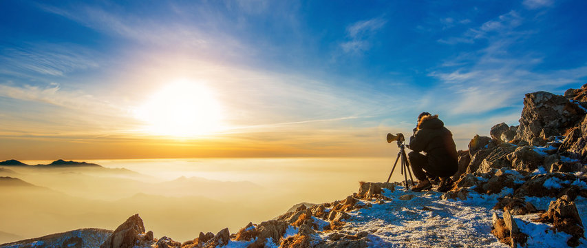 Professional photographer takes photos with camera on tripod on Deogyusan mountains, South Korea.
