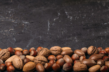 Background of mixed nuts - hazelnuts, walnuts, almonds - with copy space. 