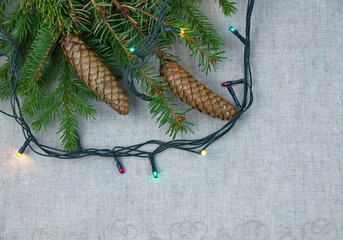 рождественская композиция еловые ветки и гирлянда на сером фоне
