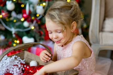 Fototapeta na wymiar little girl looks at Christmas decorations