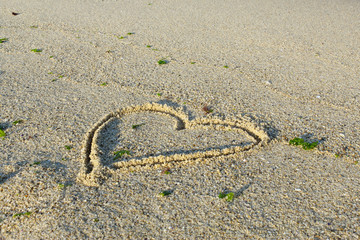 Fototapeta na wymiar Sea beach sand waves and drawings of sun, love and heart