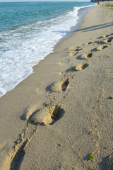 Footprints on Sea beach sand waves
