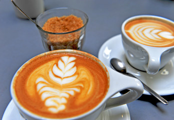 Cups of cappuccino and brown sugar