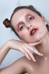 Naklejka premium Girl with wet make-up posing emotionally on a blue background