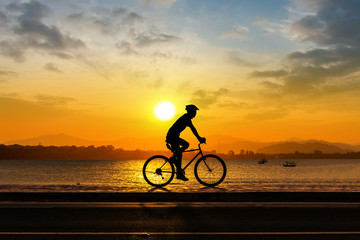 Naklejka na ściany i meble Man cycling at beach evening time