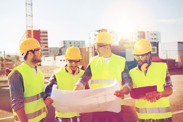 group of builders with tablet pc and blueprint