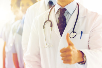 close up of happy doctor showing thumbs 