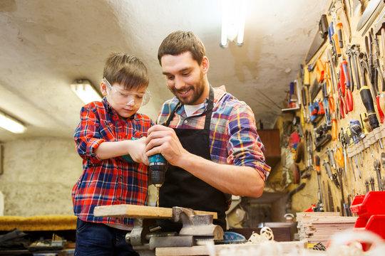 father and son with drill working at workshop