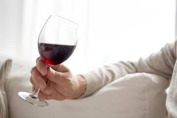 close up of hand holding glass with red wine