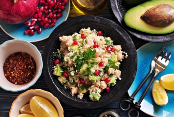 Salad of sprouted chickpeas with couscous, avocado, parsley, olive oil and pomegranate