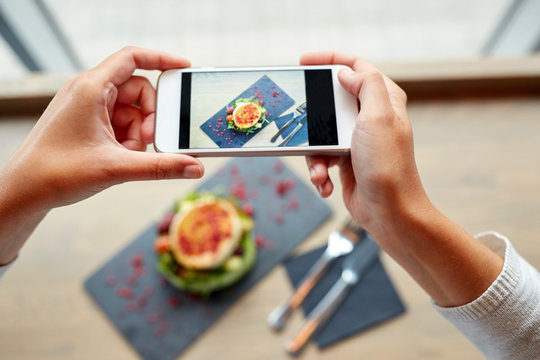 hands with smartphone photographing food