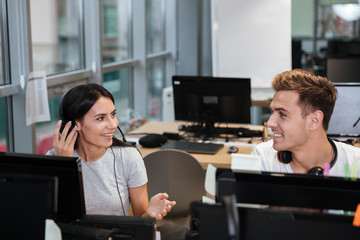 Coworkers sit by the table in headphones