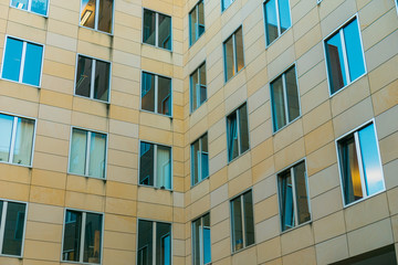 office building in a corner with orange facade and blue windws