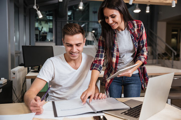 Happy coworkers looking at documents in office