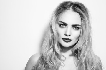 Fototapeta premium Black and white portrait of young beautiful woman with bold eyebrows and long messy hair