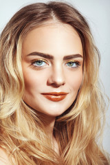 Fototapeta premium Portrait of young beautiful girl with long messy hair and golden make-up