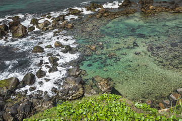 Aerial view of a tropical island with blue clear water, coral re