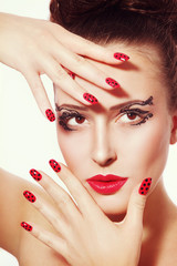 Portrait of young beautiful woman with fancy feather eyebrows and dot manicure