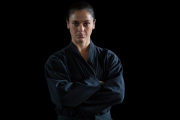 Female karate player standing with arms crossed