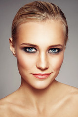 Portrait of young beautiful tanned woman with freckles and smoky eye make-up