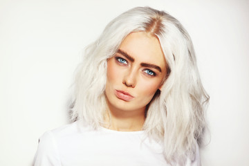 Portrait of young beautiful platinum blond woman with bold eyebrows