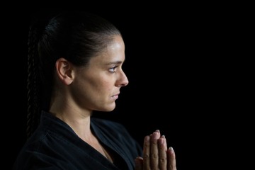 Female karate player in prayer pose - Powered by Adobe