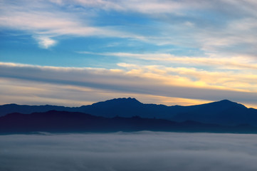 Bright sunrise, the mist in a mountain valley and mountain peaks