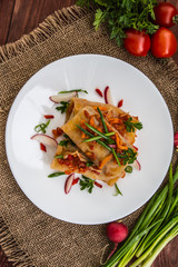 Cabbage rolls in tomato sauce. white plate. wood background. Top view