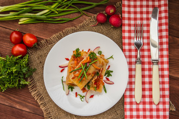 Cabbage rolls in tomato sauce. white plate. wood background. Top view