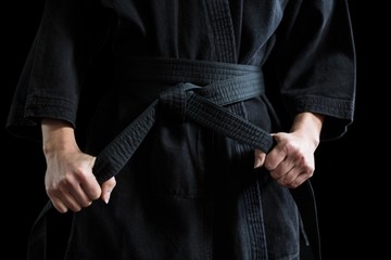 Confident karate player holding his belt