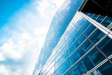 Fototapeta na wymiar View of modern contemporary glass skyscraper reflecting the blue sky