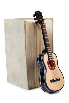 Old book and guitar on a white background