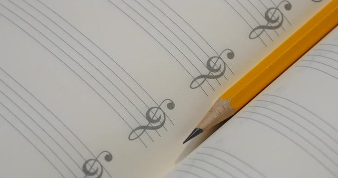 Pencil on music note book in rotation