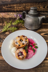 Cheesecakes with cherries and currants covered  powdered sugar on a wooden background