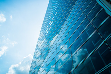 Fototapeta na wymiar View of modern contemporary glass skyscraper reflecting the blue sky