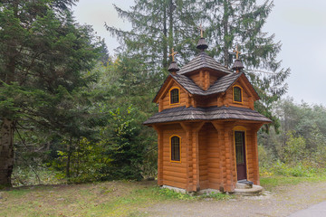 Fototapeta na wymiar Wooden rural chapel near the road. Carpathians