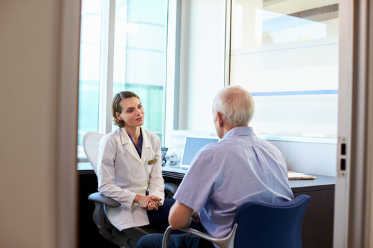Doctor In Consultation With Male Patient In Office