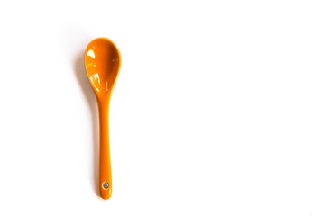 Orange spoon isolated on white background, top view