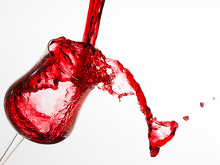 bicchiere di vetro con vino rosso che viene versato
