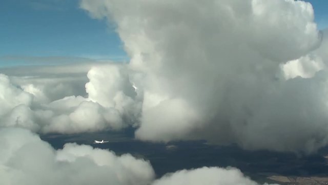 The plane is flying between the clouds