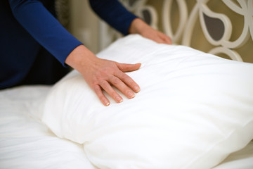 Fototapeta na wymiar Room service. Woman making bed in hotel room.