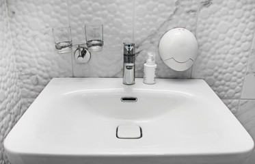Bathroom interior. Sink with glasses and soap.