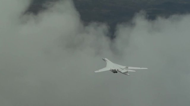 Military plane flying through the clouds