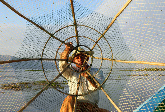 Fisherman silhouette with net at Inle lake