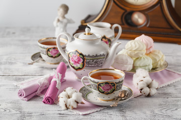 Cup of tea and  marshmallow with teapot over white background