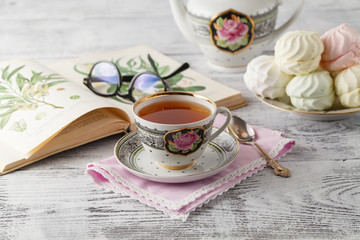 Cup of tea, book on wooden table