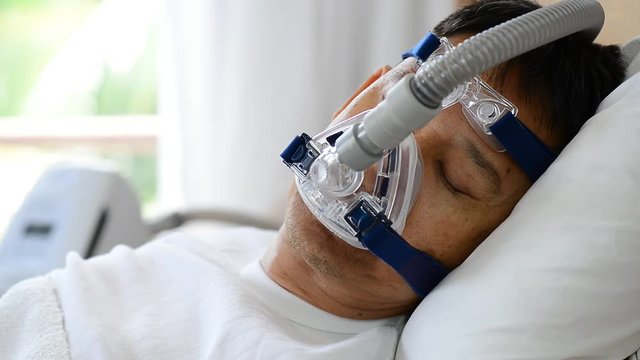 Sleep apnea therapy, Man sleeping in bed wearing CPAP mask.
Healthy senior man sleeping deeply happy on his back without snoring
